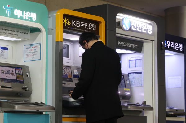 한 고객이 KB국민은행 ATM기기에서 은행 업무를 보고 있다. / 사진 = 연합뉴스