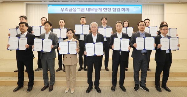 임종룡 우리금융그룹 회장(앞줄 왼쪽 네 번째)이 27일 서울 중구 우리금융그룹 본사에서 열린 '내부통제 현장점검회의'에서 참석자들과 결의문을 들고 기념 촬영하고 있다 / 사진=우리금융