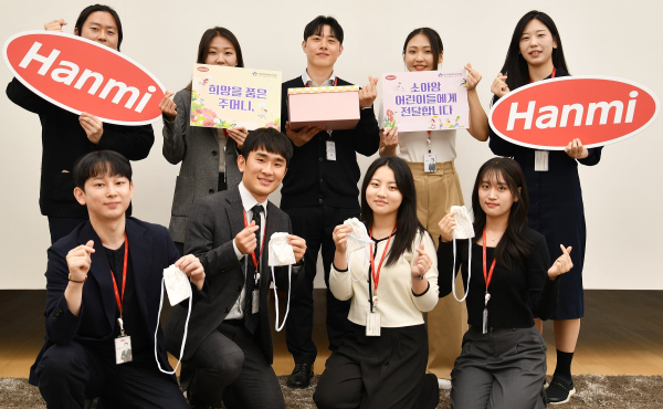 @ 한미사이언스와 한미약품 직원들이 소아암 환아를 위한 응원의 마음을 담아 손수 제작한 ‘히크만 주머니’를 들고 기념촬영을 하고 있다. /사진=한미사이언스